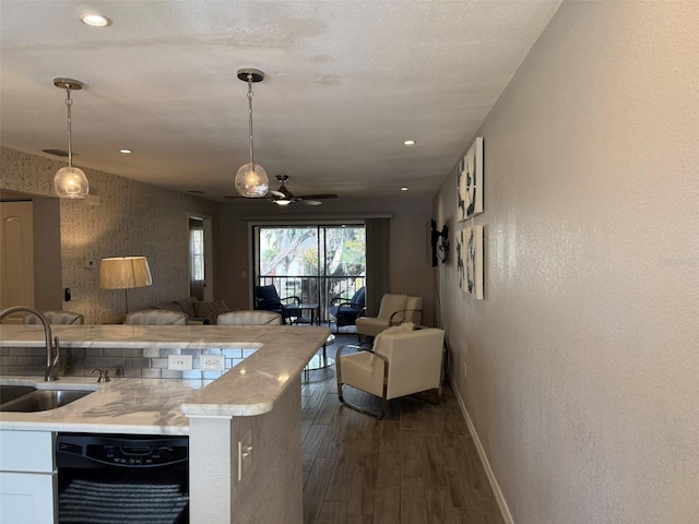 kitchen with dark hardwood / wood-style flooring, sink, white cabinets, black dishwasher, and hanging light fixtures