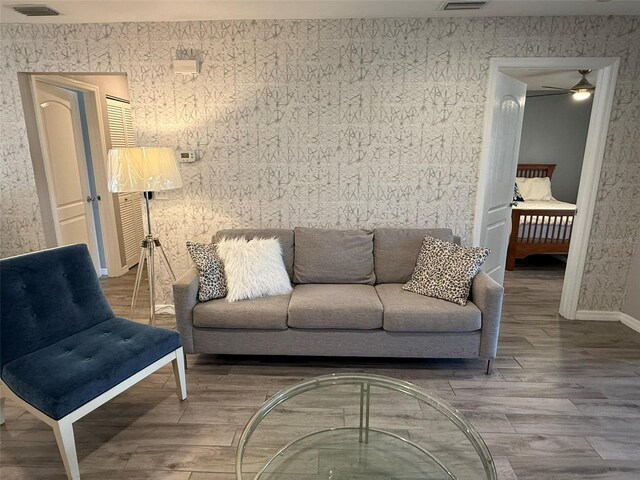 living room featuring wood-type flooring and ceiling fan