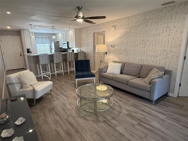 living room with ceiling fan and wood-type flooring