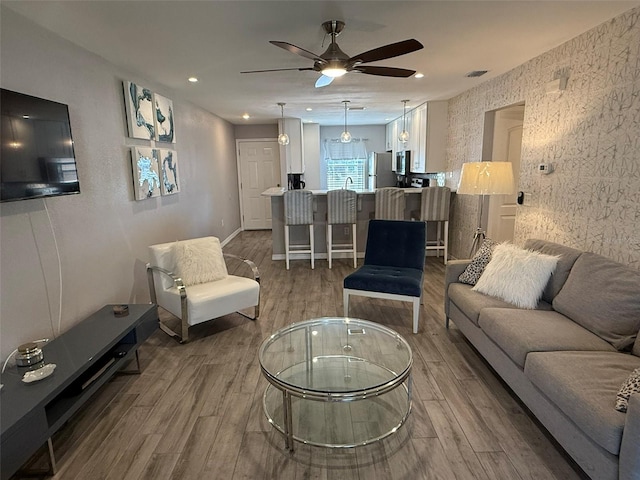 living room featuring ceiling fan, hardwood / wood-style floors, and sink