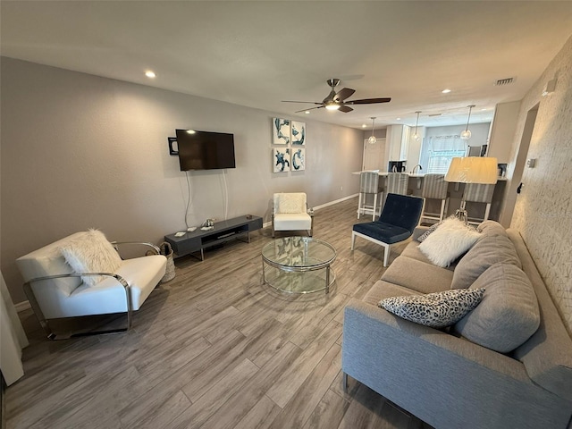 living room with wood-type flooring and ceiling fan