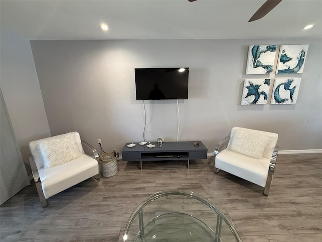 living area with hardwood / wood-style flooring and ceiling fan