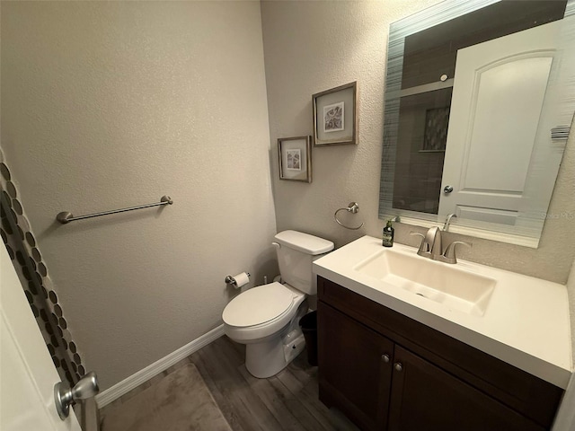 bathroom with toilet, vanity, and hardwood / wood-style flooring