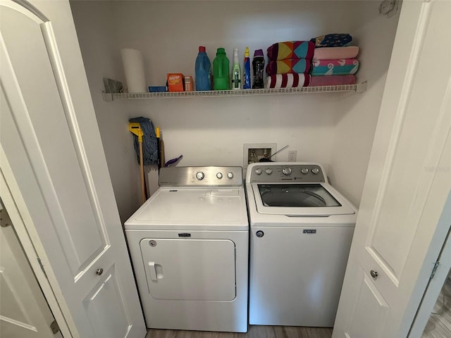 laundry room with washer and dryer and wood-type flooring