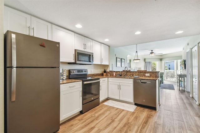 kitchen with white cabinetry, light hardwood / wood-style flooring, kitchen peninsula, pendant lighting, and appliances with stainless steel finishes