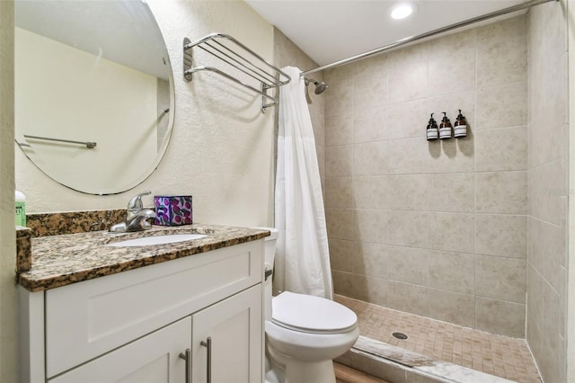 bathroom with a shower with shower curtain, vanity, and toilet