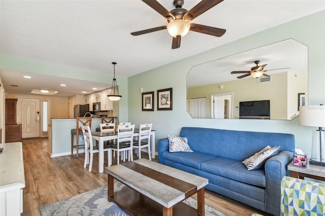 living room with hardwood / wood-style flooring and ceiling fan