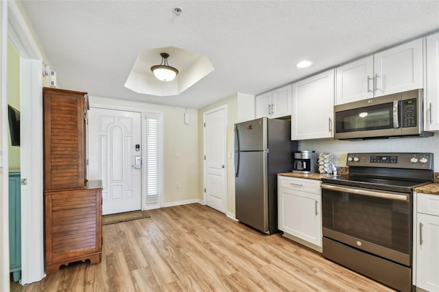 12000 Gulf Blvd Unit 208-S, Treasure Island, FL 33706 - kitchen featuring stainless steel appliances, light wood finished floors, white cabinetry, recessed lighting, and stone countertops