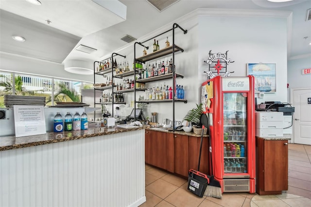 bar featuring light tile patterned floors and crown molding