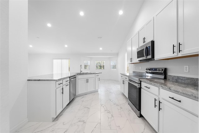 kitchen with white cabinets, stone countertops, and appliances with stainless steel finishes