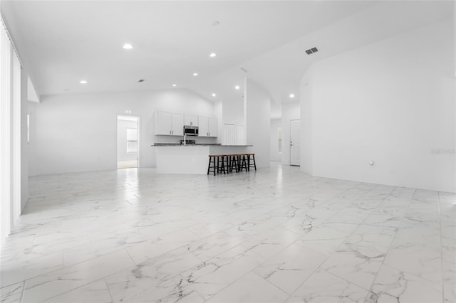 unfurnished living room with vaulted ceiling