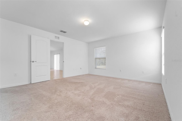 unfurnished room featuring light carpet