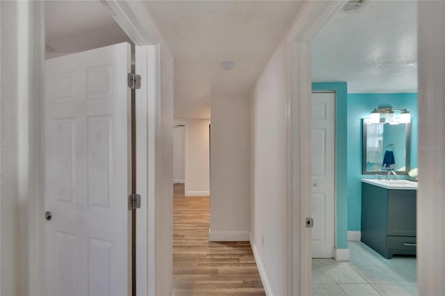 hallway featuring a textured ceiling and sink