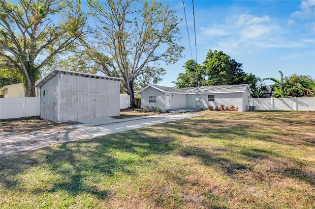 view of yard with central AC unit and a storage shed