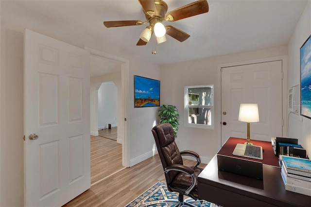 home office with light hardwood / wood-style floors and ceiling fan