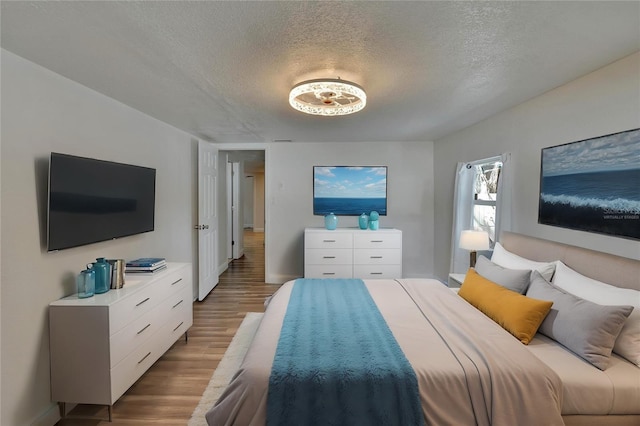 bedroom featuring a textured ceiling and hardwood / wood-style flooring