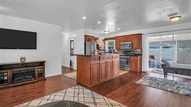 kitchen with decorative backsplash, a center island, dark wood-type flooring, and appliances with stainless steel finishes