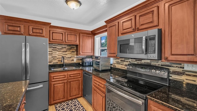 kitchen featuring black appliances, sink, dark stone counters, and tasteful backsplash