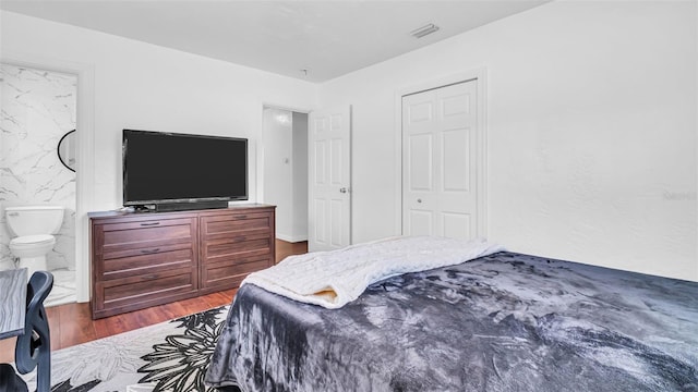 bedroom featuring dark hardwood / wood-style floors and connected bathroom