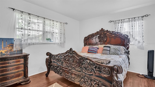 bedroom featuring dark wood-type flooring and multiple windows