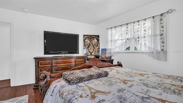 bedroom with dark hardwood / wood-style flooring