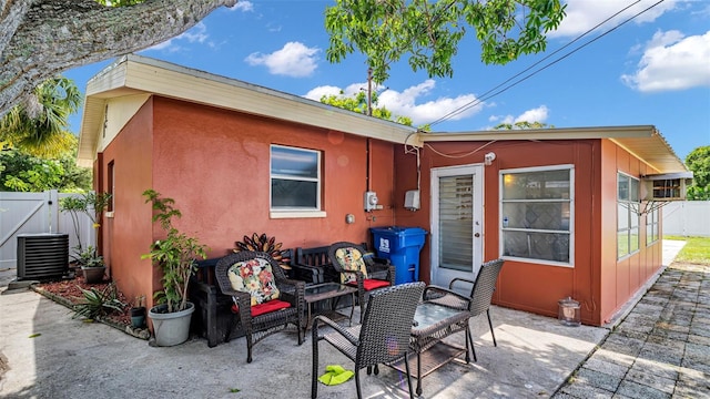 rear view of house featuring a patio, an outdoor hangout area, and central AC unit