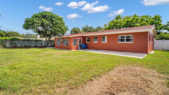 back of property with a yard and a patio area