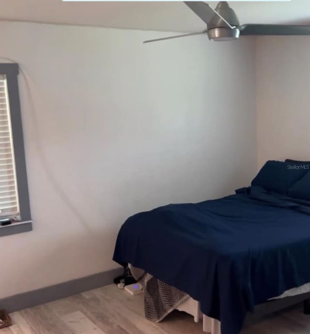 bedroom with wood-type flooring and ceiling fan