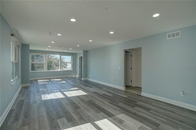 empty room featuring wood-type flooring and a textured ceiling