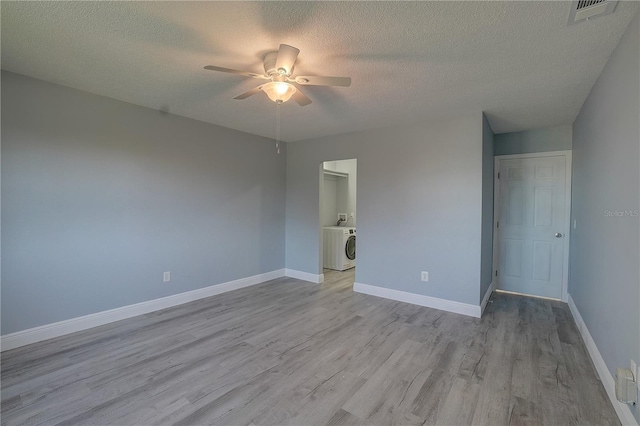 unfurnished bedroom featuring light wood-type flooring, washer / dryer, a textured ceiling, and ceiling fan