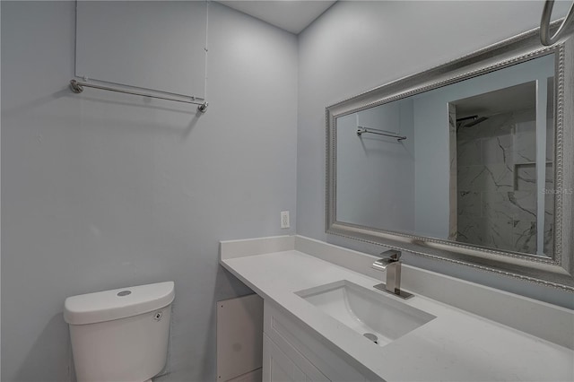 bathroom with a shower, vanity, and toilet