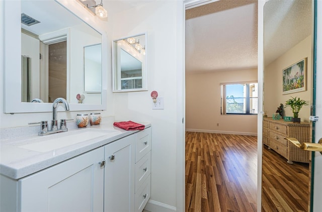 bathroom with vanity, hardwood / wood-style flooring, and a textured ceiling