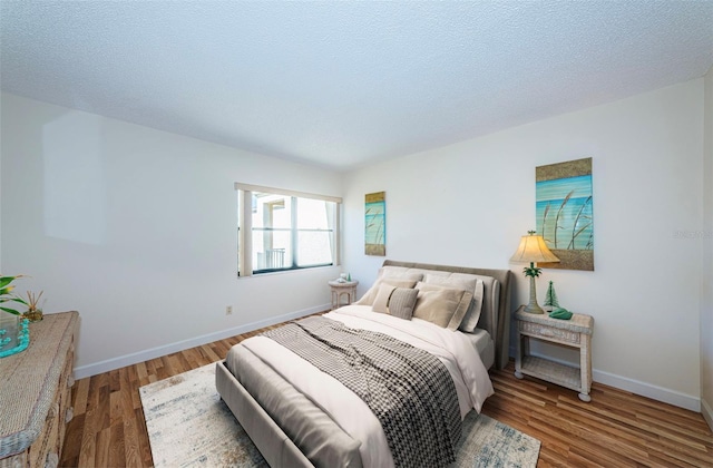 bedroom with wood-type flooring and a textured ceiling