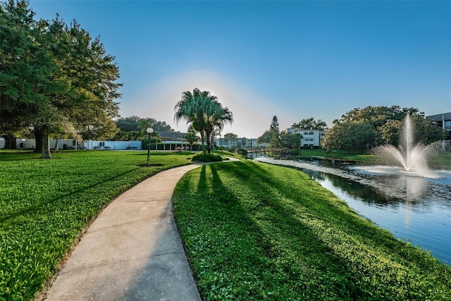 view of home's community featuring a water view and a lawn