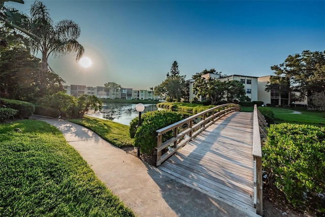 surrounding community featuring a water view and a lawn