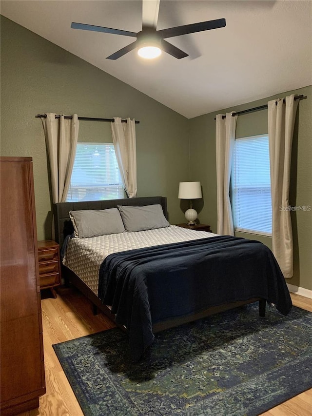 bedroom featuring ceiling fan, hardwood / wood-style floors, and lofted ceiling