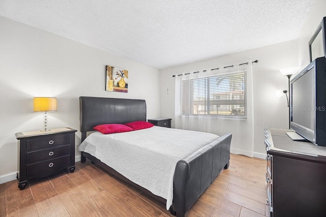 bedroom featuring hardwood / wood-style floors and a textured ceiling