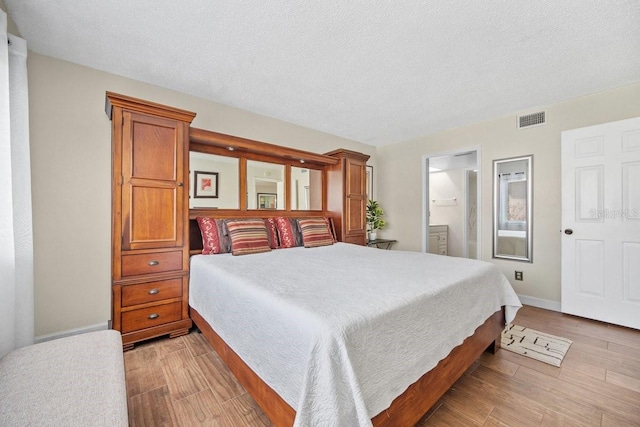 bedroom featuring light hardwood / wood-style floors and a textured ceiling