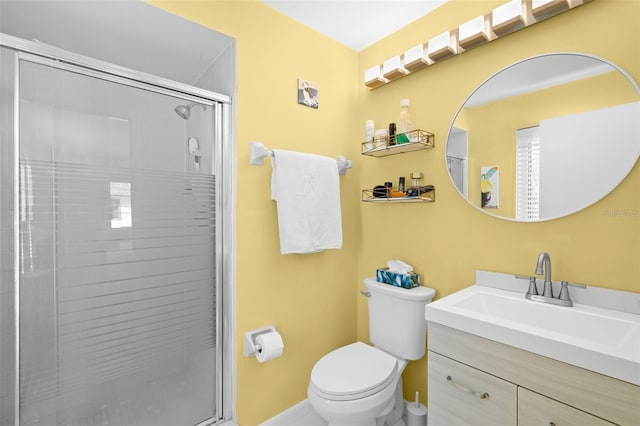 bathroom with an enclosed shower, vanity, and toilet