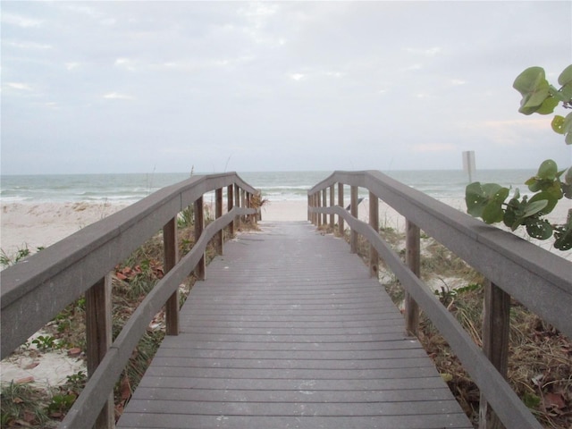 view of dock with a water view and a view of the beach