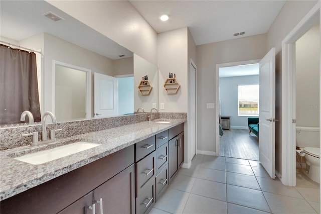 bathroom featuring tile patterned flooring, vanity, and toilet