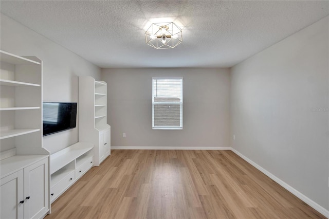 unfurnished living room featuring a textured ceiling and light hardwood / wood-style floors