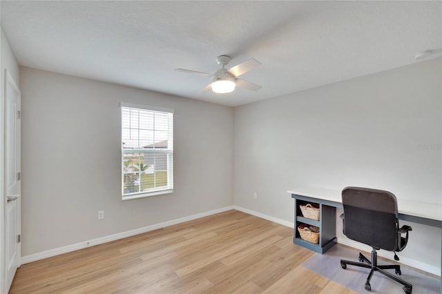 home office with light wood-type flooring and ceiling fan