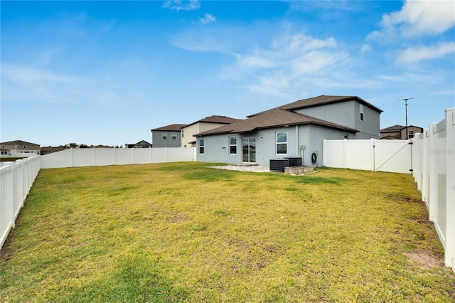 back of house with a lawn and central air condition unit