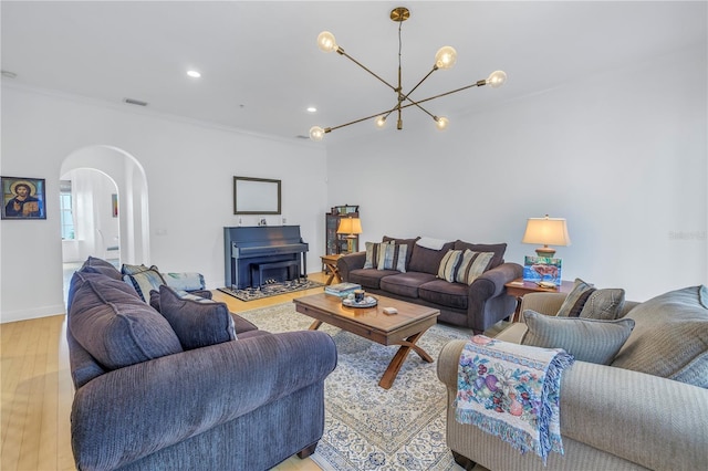 living room with ornamental molding, light hardwood / wood-style flooring, and a notable chandelier