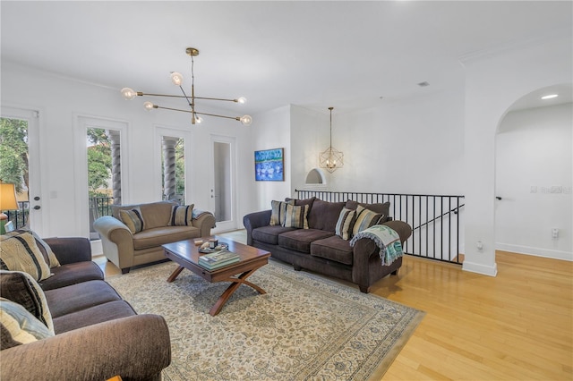 living room with crown molding, light hardwood / wood-style flooring, and a notable chandelier