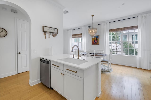 kitchen featuring stainless steel dishwasher, sink, pendant lighting, light hardwood / wood-style flooring, and white cabinets