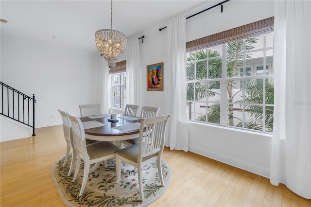 dining space with a notable chandelier, plenty of natural light, and light wood-type flooring