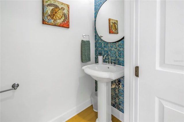 bathroom featuring hardwood / wood-style flooring, tile walls, and sink