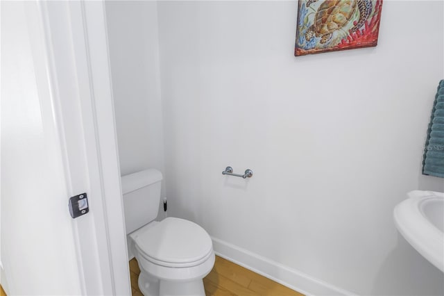 bathroom with sink, hardwood / wood-style floors, and toilet